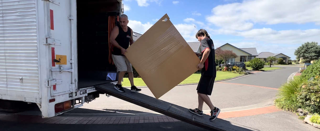 House movers carrying a sofa during a Waikato home move